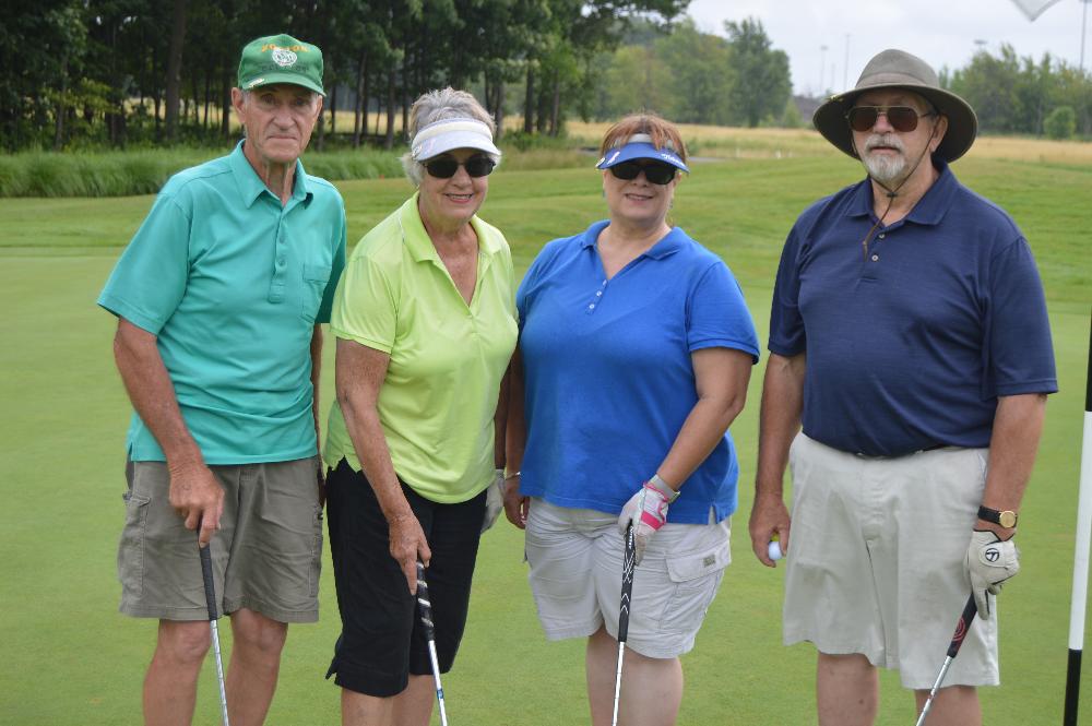 A golf team of 4 alumni.